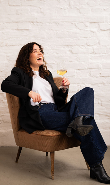 Laura sitzt und lacht