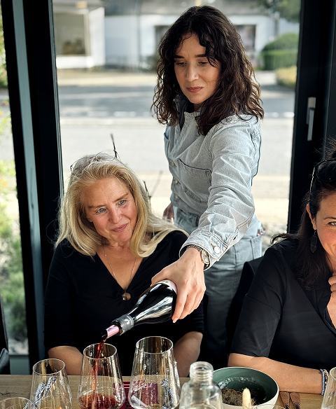 Laura schenkt Wein aus