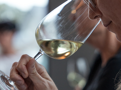 Person riecht an Weinglas